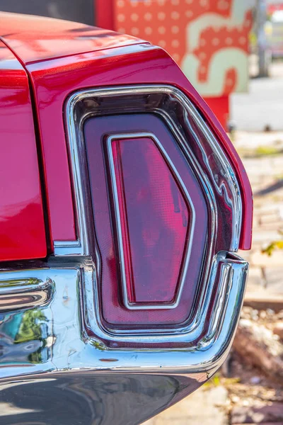 The red brake light or taillight of a red classic car or Muscle- Car in the streets