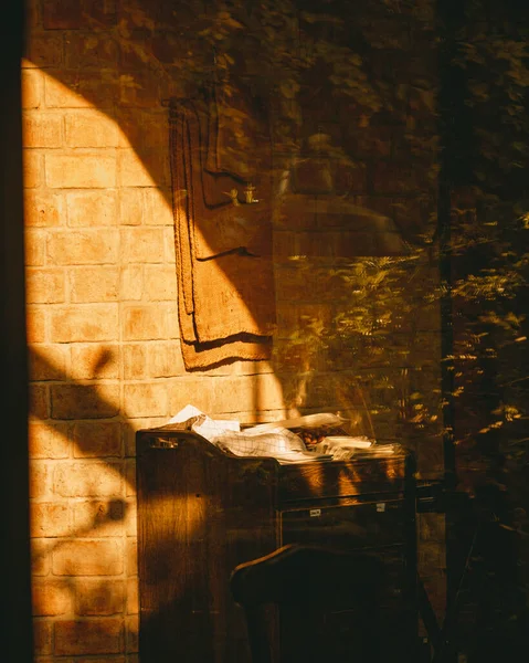 Pionowe Ujęcie Słońca Świecącego Przez Okno Pobliżu Biurka — Zdjęcie stockowe
