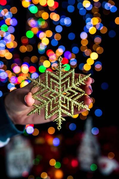 Hombre Sosteniendo Una Decoración Contra Las Luces Navideñas Bokeh — Foto de Stock