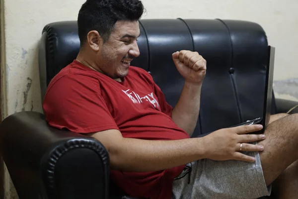 Hispanic Male Sitting Couch Looking Laptop Surprise — ストック写真