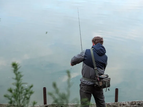 Young Caucasian Man Catching Fish Fishing Rod Lake — Stockfoto
