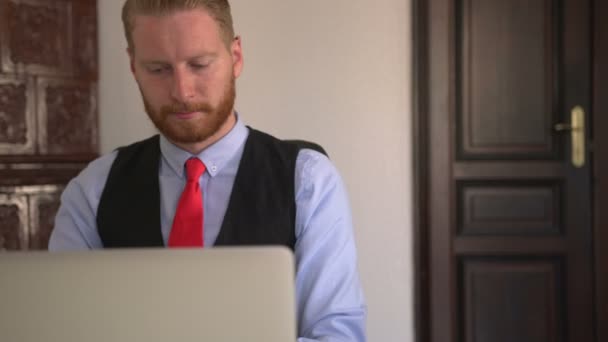 Νεαρός Όμορφος Καυκάσιος Επιχειρηματίας Που Χρησιμοποιεί Φορητό Υπολογιστή Στο Γραφείο — Αρχείο Βίντεο