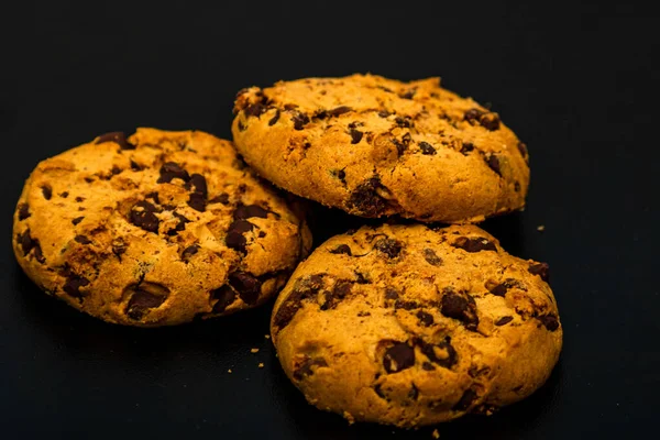 黒の背景に隔離されたおいしいチョコレートチップクッキー — ストック写真