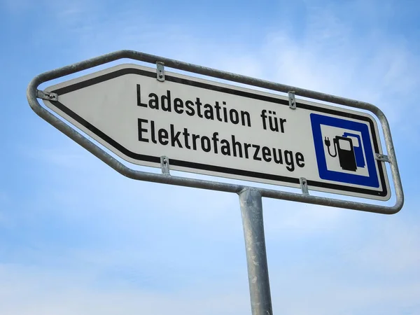 Een Bord Laadstation Voor Elektrische Voertuigen Achtergrond Van Een Bewolkte — Stockfoto