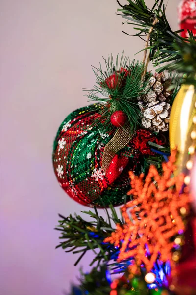 ライトアップされたクリスマスツリーに掛けられた美しい装飾や装飾品の垂直ショット — ストック写真