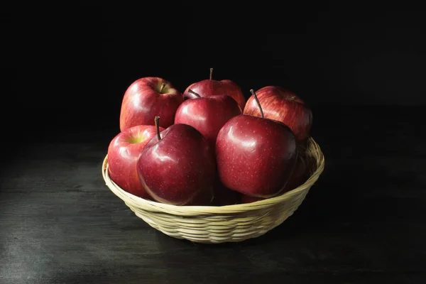 Csendélet Szalmakosár Vörös Almával Sötét Asztal Felett — Stock Fotó
