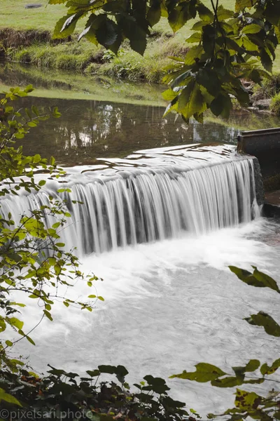 小川の上の小さな滝の垂直ショット — ストック写真