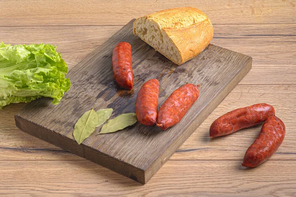Closeup Raw Fresh Sausages Bread Lettuce Wooden Cutting Board — Stock Photo, Image