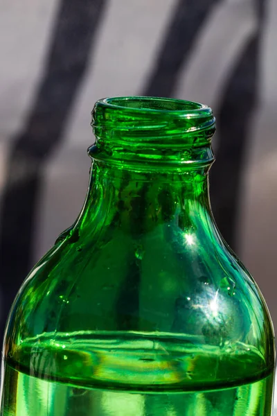 Ένα Κάθετο Πλάνο Της Άκρης Ενός Πράσινου Μπουκαλιού Ένα Θολό — Φωτογραφία Αρχείου