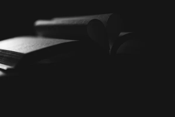 心を形成する本のページの暗いクローズアップショット — ストック写真