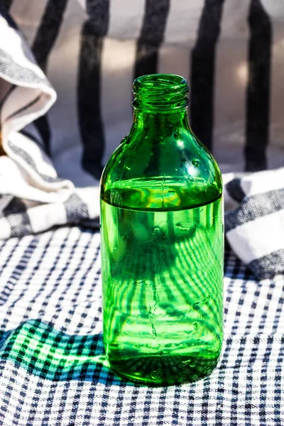 Een Verticaal Shot Van Een Groene Fles Water Een Tafel — Stockfoto