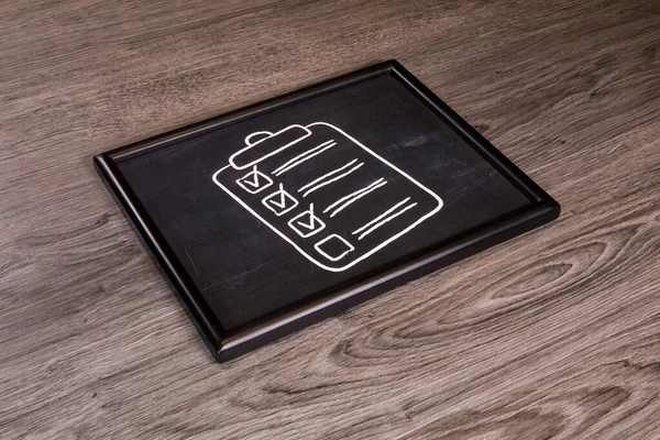 Eine Checkliste Auf Kreidetafel Tafel Vor Grauem Holzhintergrund — Stockfoto