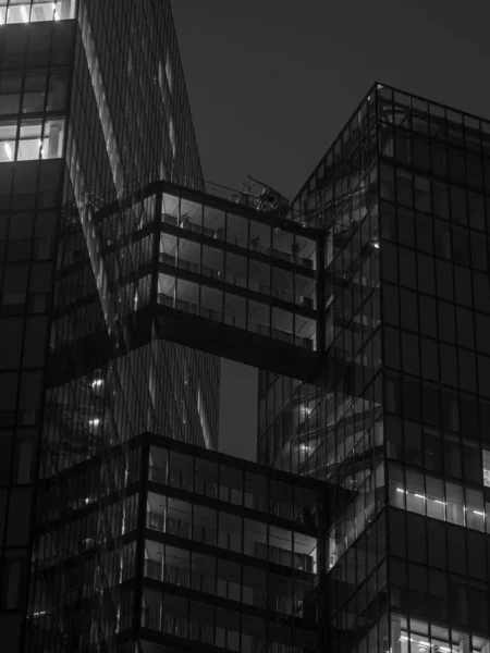 美丽的现代建筑在夜间的垂直灰度拍摄 灯光闪烁着 — 图库照片