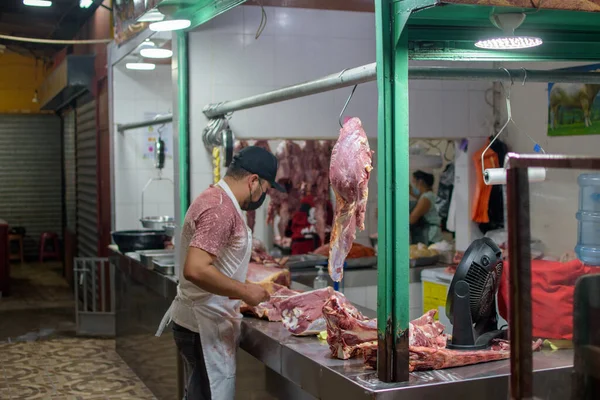 肉屋で肉を切る顔のマスクの肉屋 — ストック写真