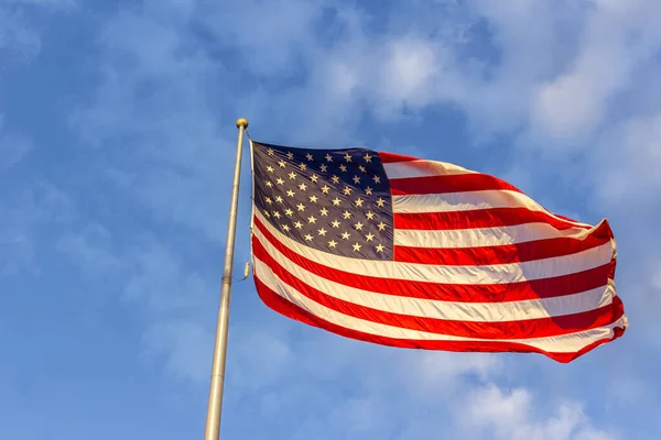 晴れた日に青い曇り空に向かって手を振っているアメリカ国旗のクローズアップショット — ストック写真