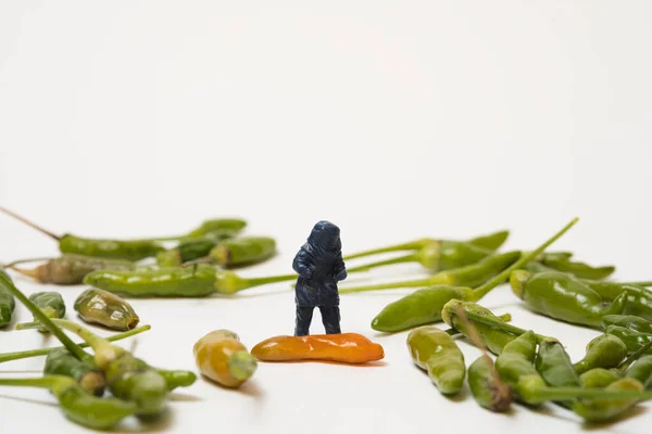 Een Miniatuur Figuur Met Beschermende Kleding Die Groene Chili Pepers — Stockfoto
