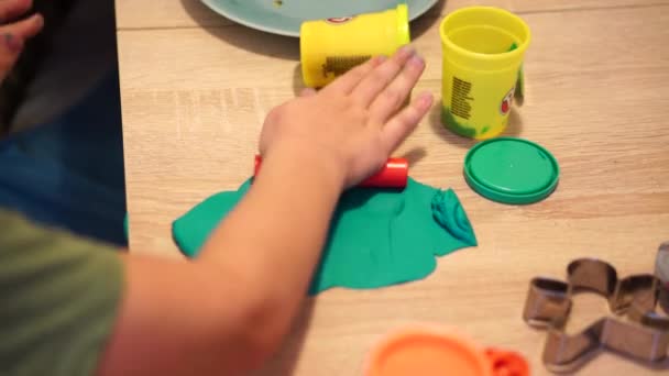 色のついたプラスチックで遊ぶ子供の手のクローズアップ映像 — ストック動画