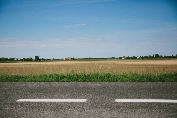 Eine Straße Die Einem Sonnigen Tag Von Einem Feld Umgeben — Stockfoto