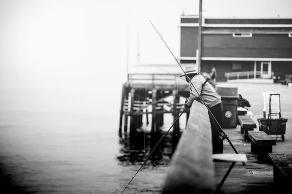 Серый Снимок Рыбака Стоящего Пирсе Стержнем — стоковое фото