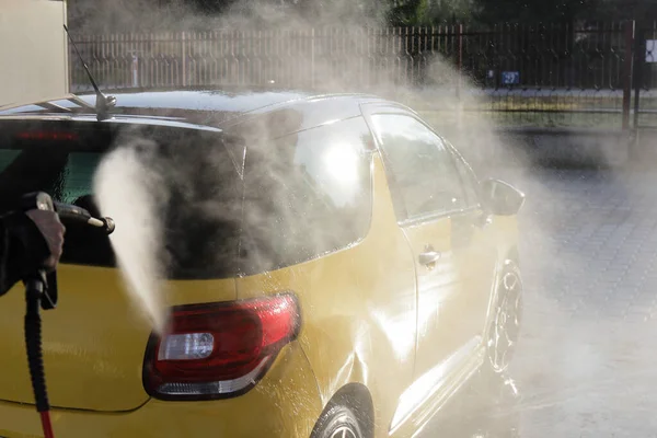 洗車場で黄色の車を洗う男の手 — ストック写真