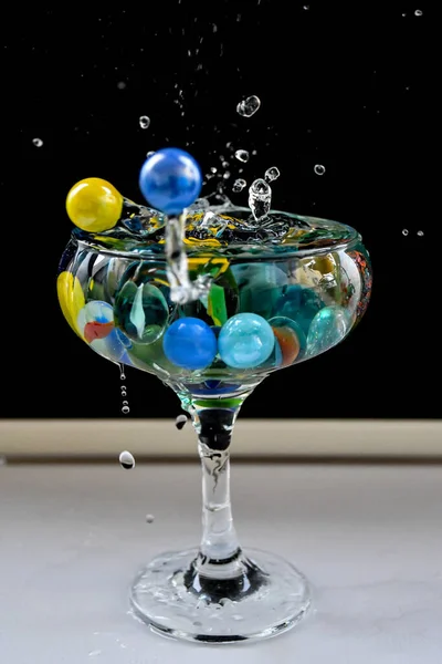 小さなカラフルなボールを持つ水のガラス — ストック写真
