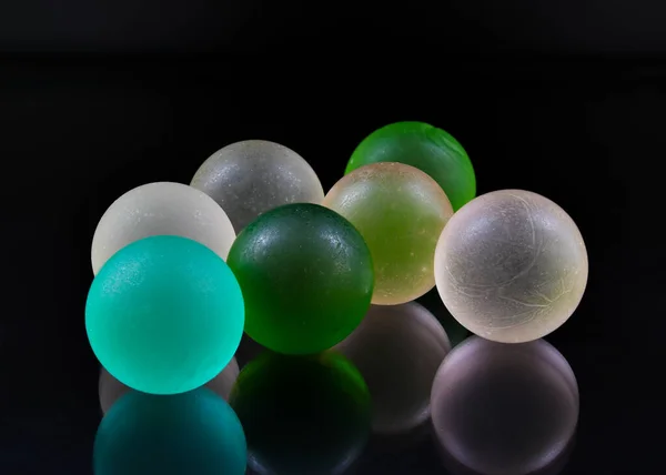 Closeup Shot Colorful Small Balls Black Reflective Surface — Foto Stock