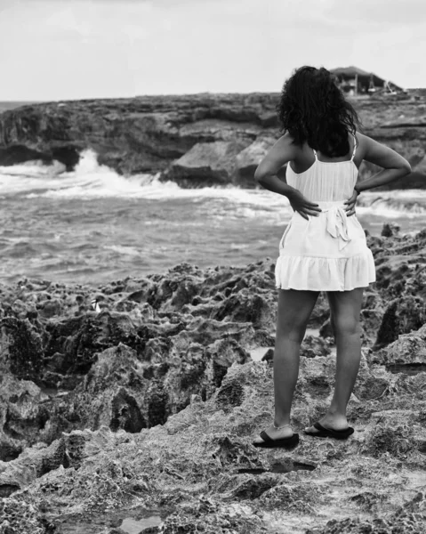 一个年轻女子背着背包在海滩上的黑白照片 — 图库照片