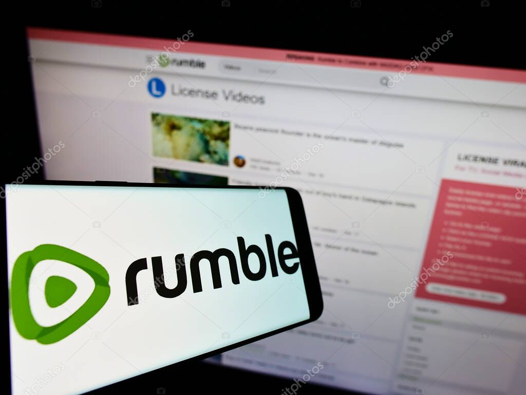 Rumble logo on smartphone screen and computer monitor