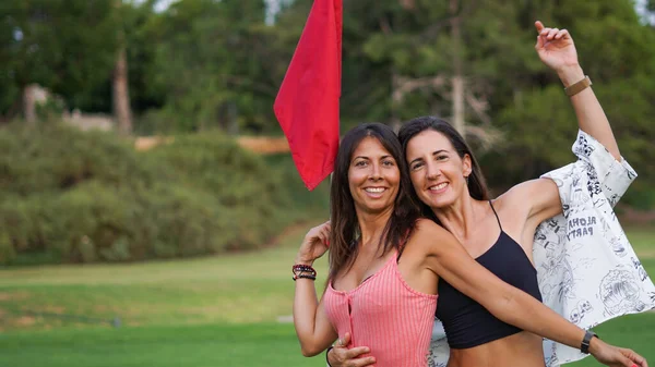 Young Female Couple Park Red Flag — Fotografia de Stock