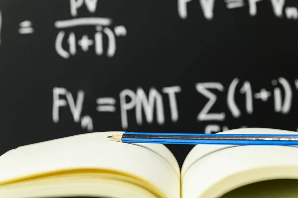 Closeup Pencil Open Notebook Blackboard Equations Background —  Fotos de Stock
