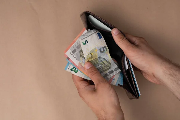 Overhead Man Holding His Wallet Full Euro Banknotes Brown Surface — Foto Stock