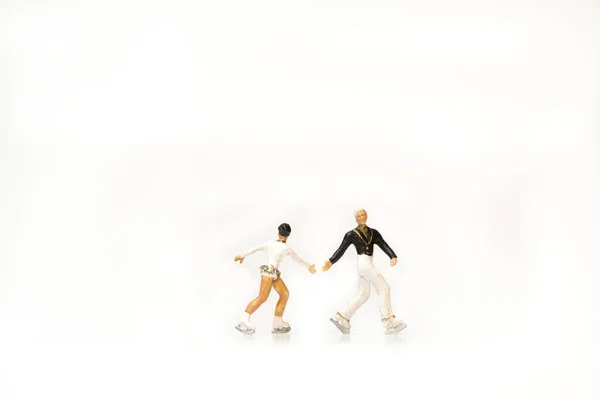 Twee Miniatuurfiguren Van Schaatsers Een Witte Achtergrond — Stockfoto