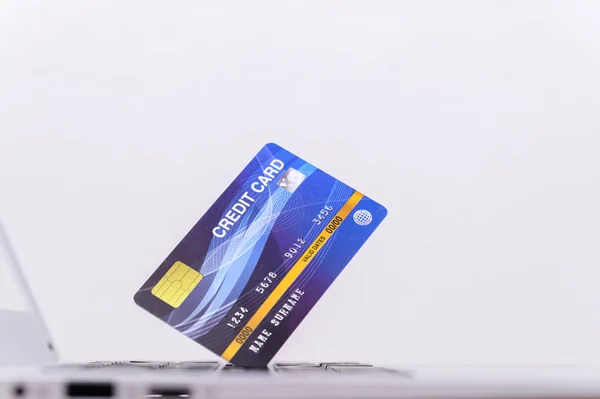 Μια Μπλε Πιστωτική Κάρτα Ένα Φορητό Υπολογιστή Που Απομονώνεται Λευκό — Φωτογραφία Αρχείου