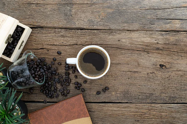 Egy Csésze Kávé Kávébabbal Egy Jegyzetfüzettel Asztalon — Stock Fotó