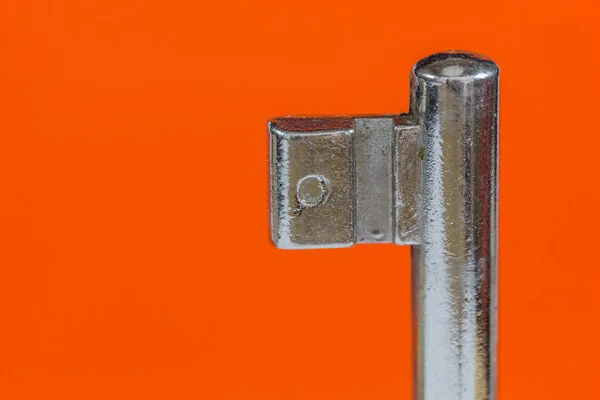 Ein Silberner Schlüssel Isoliert Auf Orangefarbenem Hintergrund — Stockfoto