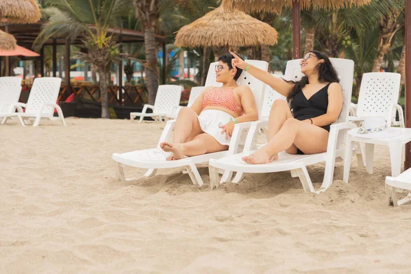 Two female tourists on the private beach of Punta Centinela in Ecuador