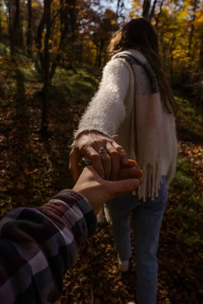 Pionowe Ujęcie Młodej Pary Trzymającej Się Ręce Lesie Jesienią — Zdjęcie stockowe