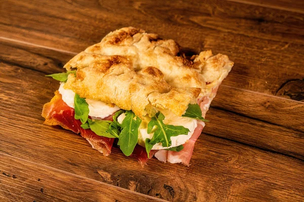 用腊肠和蔬菜装饰在木制表面的三明治 — 图库照片
