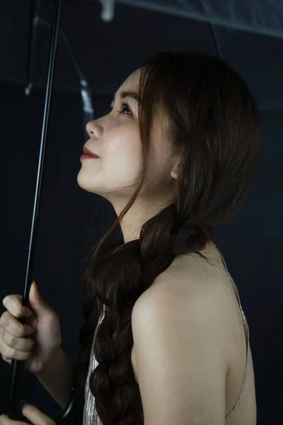 一个穿着黑色背景雨伞的年轻漂亮女子的肖像 — 图库照片