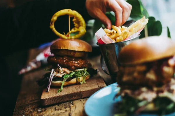 burger with beef, cheese and fries on wooden table