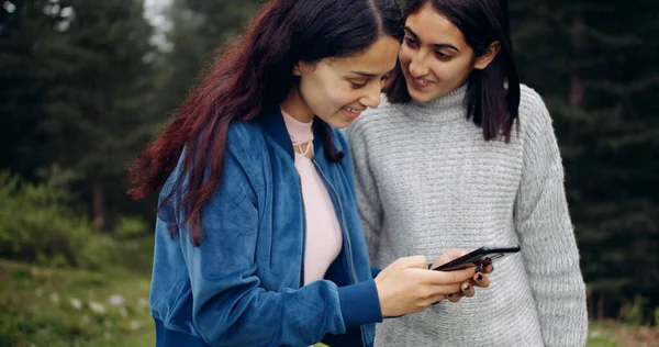 Νεαρή Γυναίκα Και Φίλοι Της Κοιτάζονται Ενώ Χρησιμοποιούν Ένα Smartphone — Φωτογραφία Αρχείου