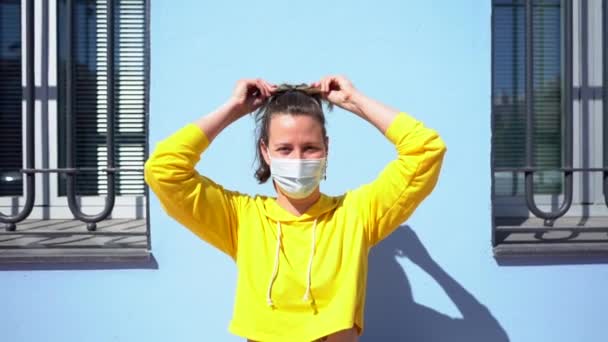 Ung Kvinna Med Skyddande Mask Den Blå Väggen Bakgrund — Stockvideo
