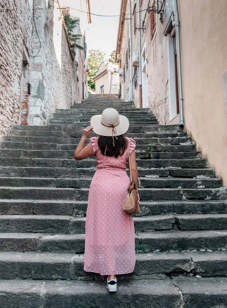 意大利 一个头戴帽子 身穿白衣的年轻女子在街上行走 — 图库照片