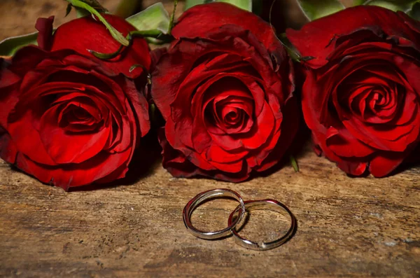 Rose Rosse Fedi Nuziali Uno Sfondo Legno — Foto Stock