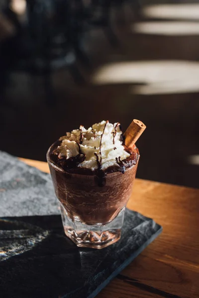 木のテーブルの上にホイップの種とミントの入ったチョコレートアイス — ストック写真