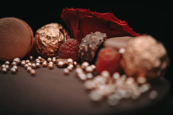 Schokoladenbonbons Und Nüsse Auf Schwarzem Hintergrund — Stockfoto