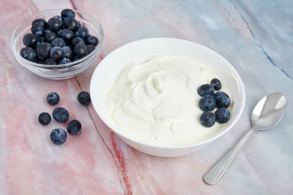 带有蓝莓和白色背景新鲜浆果的酸奶 — 图库照片