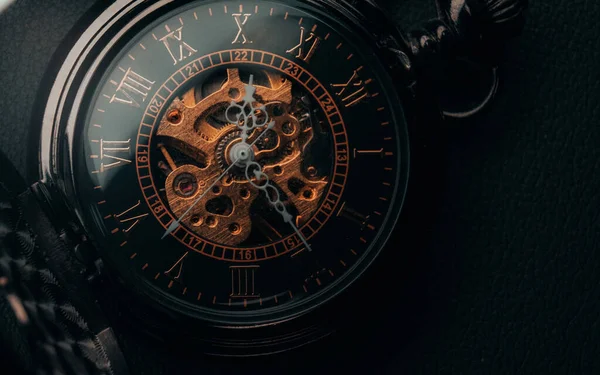 close up of a clock on a black background