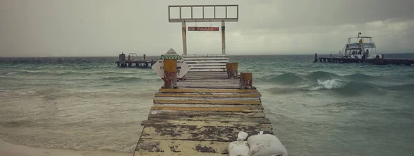 男が海の桟橋を歩いていて — ストック写真
