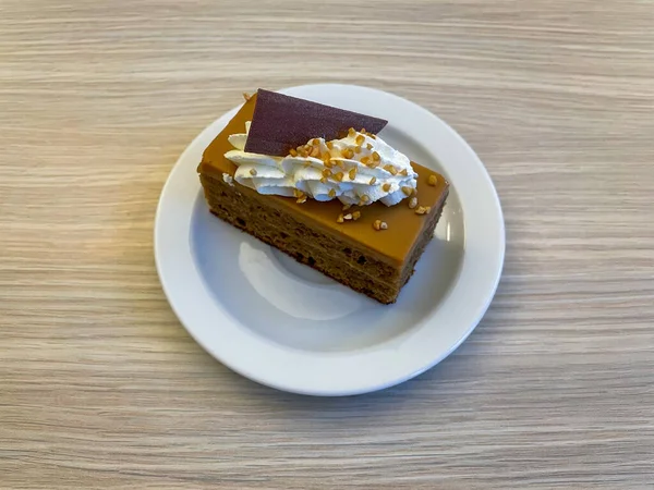 木の背景にクリームとナッツのチョコレートケーキ — ストック写真